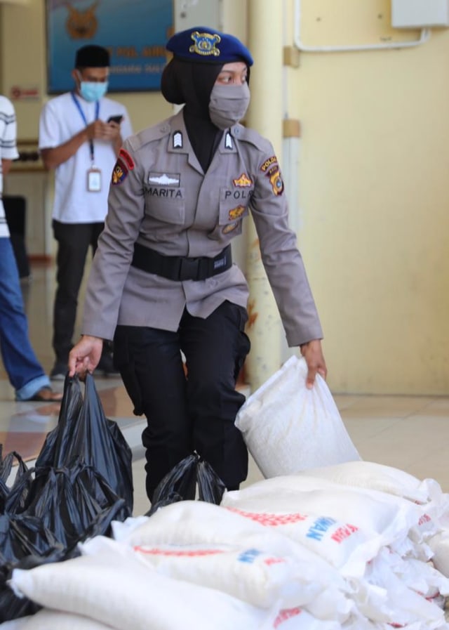Personel Ditpolairud Polda Aceh mengangkat paket sembako untuk diserahkan kepada pekerja Bandara SIM, Senin (4/5). Foto: Suparta/acehkini