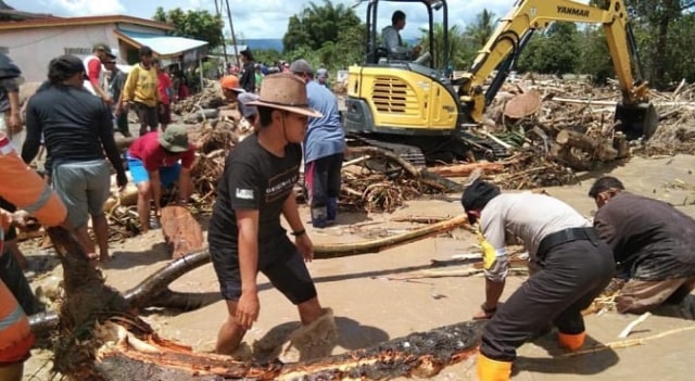 Warga dan petugas membersihkan material banjir di Poso. Foto: Istimewa 