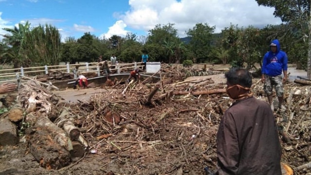Warga dan petugas membersihkan material banjir di Poso. Foto: Istimewa 
