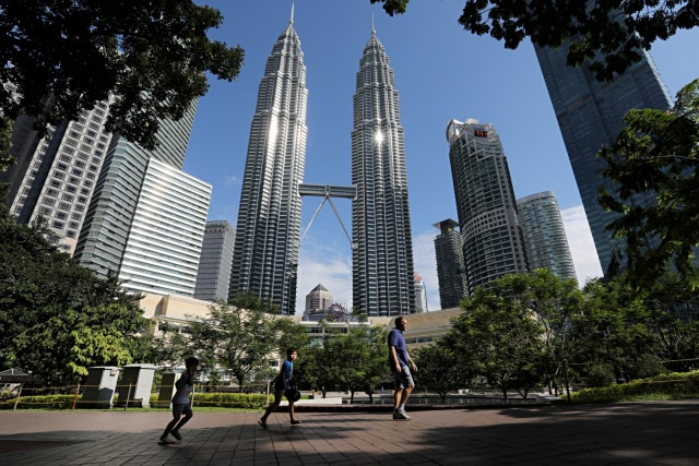 Warga berlari di sebuah taman dekat gedung kembar Petronas, Kuala Lumpur, Malaysaia, Senin (4/5). Foto: REUTERS/Lim Huey Teng