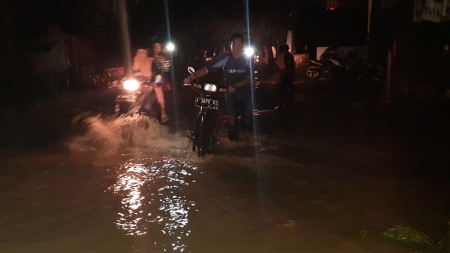 Warga mendonrong motor saat menerobos banjir di Cilegon, Banten. Foto: Dok. Istimewa