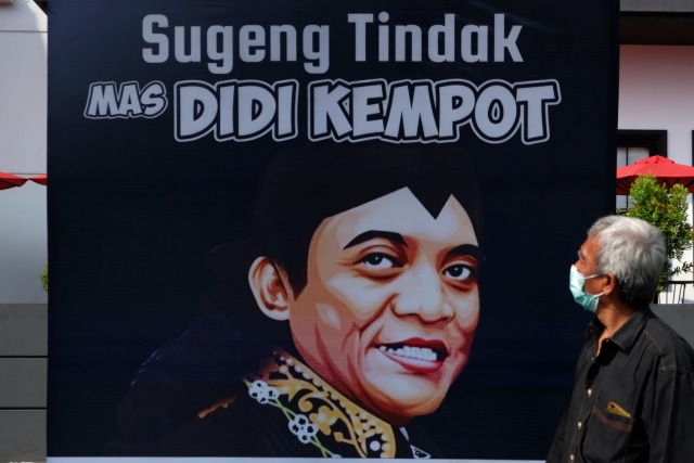 Warga melintasi poster ucapan duka cita untuk mengenang penyanyi campursari Didi Kempot yang meninggal dunia di Solo, Jawa Tengah, Selasa (5/5), Foto: ANTARAFOTO/Maulana Surya