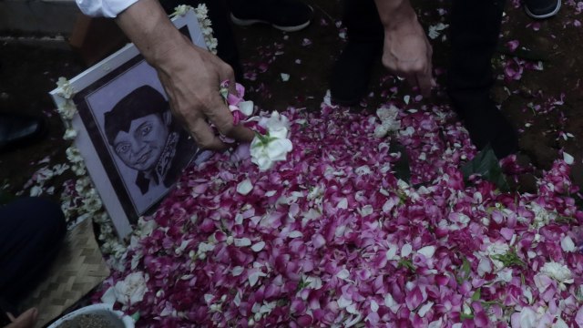 Kerabat menabur bunga di atas pusara almarhum Didi Kempot seusai dimakamkan di Tempat Pemakaman Umum Desa Majasem, Ngawi, Jawa Timur, Selasa (5/5). Foto: ANTARA FOTO/Joni Pratama