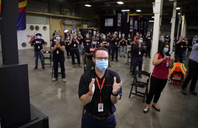 Pegawai meyambut kedatangan Presiden AS Donald Trump di pabrik masker di Phoenix, Arizona, AS, Selasa (5/5). Foto: REUTERS/Tom Brenner