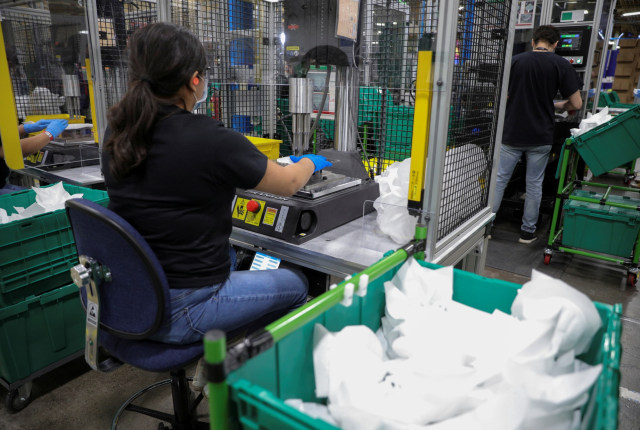 Pekerja membuat masker di pabrik Honeywell, ketika Presiden AS Donald Trump berkunjung, di Phoenix, Arizona, AS, Selasa (5/5). Foto: REUTERS/Tom Brenner