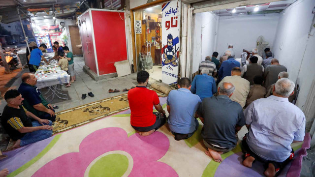 Muslim di Irak melakukan salat di sebuah toko setelah pemerintah menutup masjid-masjid. Foto: Reuters/THAIER AL-SUDANI