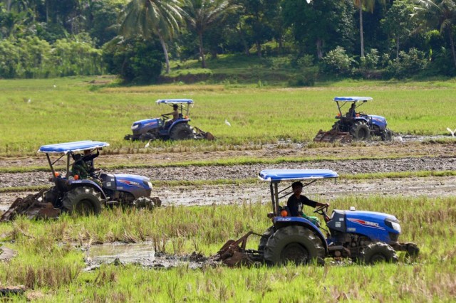 Prajurit TNI mengoperasikan traktor untuk membantu petani membajak sawah di Blang Bintang, Aceh Besar, Rabu (6/5). Foto: Suparta/acehkini