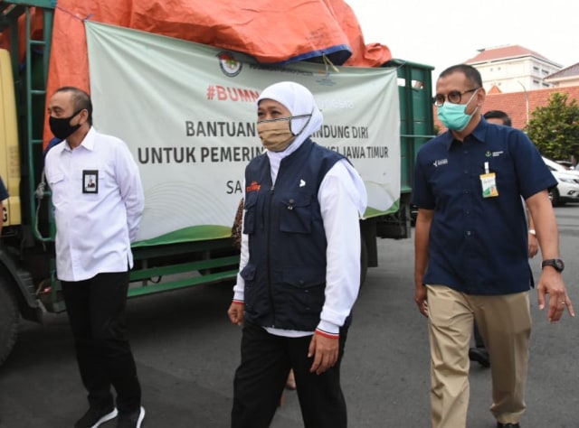 Gubernur Jatim, Khofifah Indar ParaDwansa (tengah) bersama Dirut Petrokimia Gresik, Rahmad Pribadi (kanan) saat penyerahan bantuan APD untuk rumah sakit melalui Pemprov Jatim di Surabaya, Senin (4/5).
