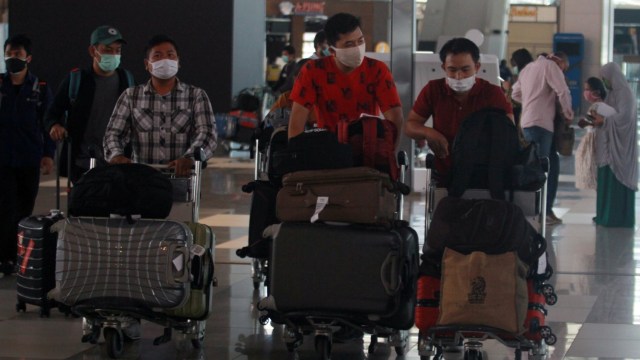 Sejumlah calon penumpang bersiap melakukan lapor diri sebelum terbang di Terminal 3 Bandara Soekarno Hatta, Tangerang, Banten. Foto:  ANTARA FOTO/Muhammad Iqbal