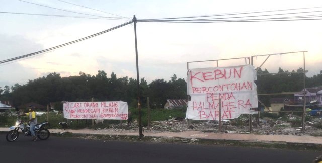 Warga Desa Gufasa, saat memasang spanduk bertuliskan: Kebun Percontohan Kabupaten Halmahera Barat", di lokasi tempat pembangunan Water Front City. Foto: istimewa