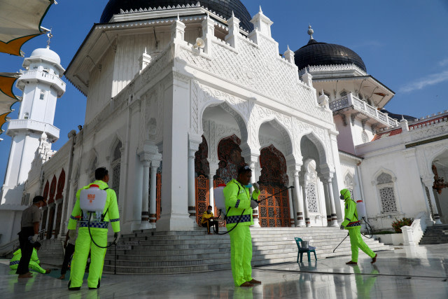 Polisi menyemprot disinfektan di Masjid Raya Baiturrahman Banda Aceh, Jumat (20/3). Foto: Suparta/acehkini
