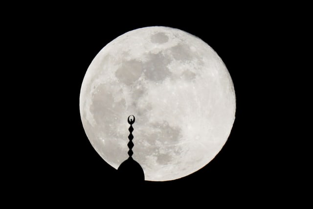 Supermoon terlihat di atas menara masjid di Amman, Yordania, Kamis (7/5/2020). Foto: REUTERS/Muhammad Hamed