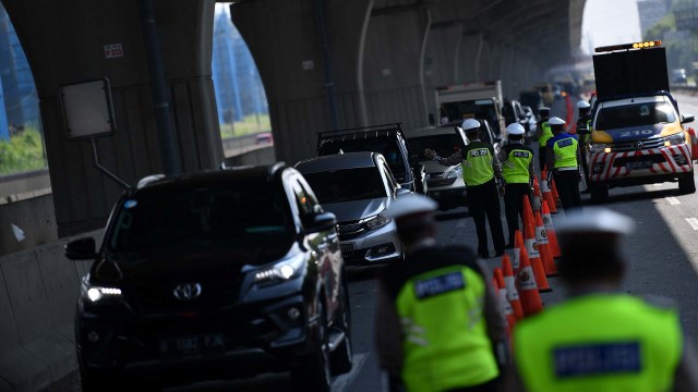 Petugas kepolisian memeriksa sejumlah kendaraan yang melintas di jalan Jakarta-Cikampek, Cikarang Barat, Jawa Barat, Kamis (7/5/2020).  Foto: ANTARA/Sigid Kurniawan