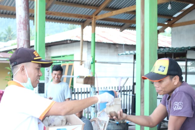 Petugas BKIPM Luwuk Banggai membagikan "Nasi Ikan" kepada Masyarakat Desa Tontouan, Kec. Luwuk (08/05/2020)