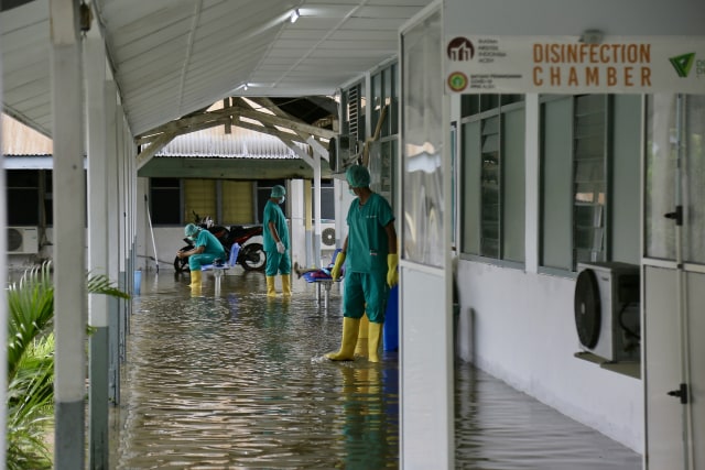 Petugas medis RSUDZA Banda Aceh tengah bekerja akibatnya ruang isolasi pasien COVID-19 terendam banjir. Foto: Abdul Hadi/acehkini