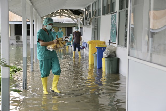 Petugas di ruang pinere RSUDZA Banda Aceh memindahkan perkakas kerjanya yang terendam banjir. Foto: Abdul Hadi/acehkini