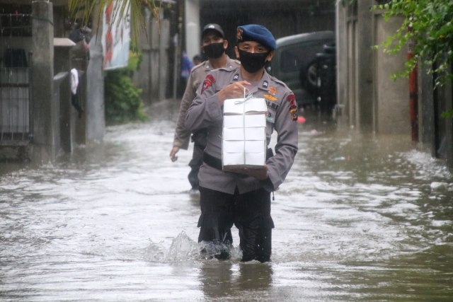 Personel Brimob Polda Aceh melewati banjir untuk membagikan takjil. Foto-foto: Polda Aceh 