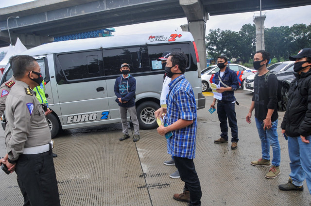 Petugas Kepolisian mengecek identitas TKI dari luar negeri di tol Jakarta-Cikampek di Cikarang Barat, Kabupaten Bekasi, Jawa Barat, Sabtu (9/5). Foto: ANTARA FOTO/ Fakhri Hermansyah