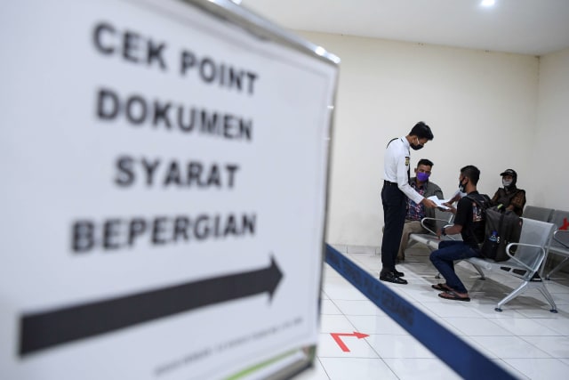 Petugas memeriksa dokumen calon penumpang yang akan berpergian menggunakan Bus AKAP (antar kota antar provinsi) di Terminal Pulogebang, Jakarta. Foto: ANTARA FOTO/Hafidz Mubarak A