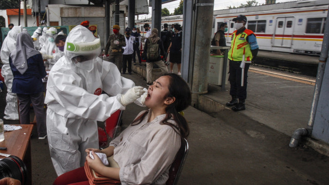 Petugas medis mengambil sampel lendir dari seorang penumpang KRL saat tes swab COVID-19 di Stasiun Bojong Gede, Bogor, Jawa Barat, Senin (11/5). Foto: ANTARA FOTO/Yulius Satria Wijaya