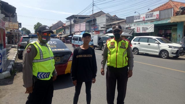 Petugas dari Polres Cirebon Kota mengamankan seorang 'Pak Ogah'. (Juan)