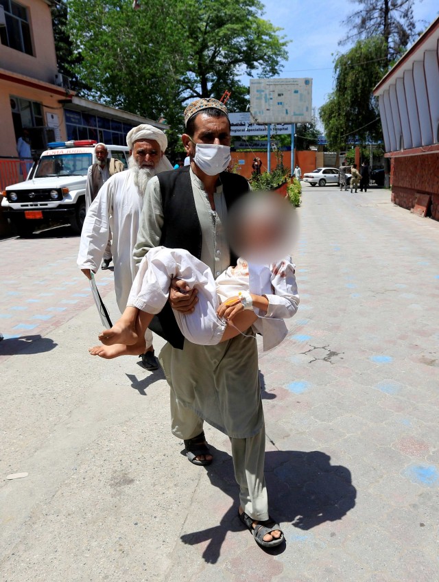 Pria membawa orang yang terluka ke rumah sakit setelah ledakan saat upacara pemakaman di Jalalabad, Afghanistan. Foto: REUTERS / Parwiz