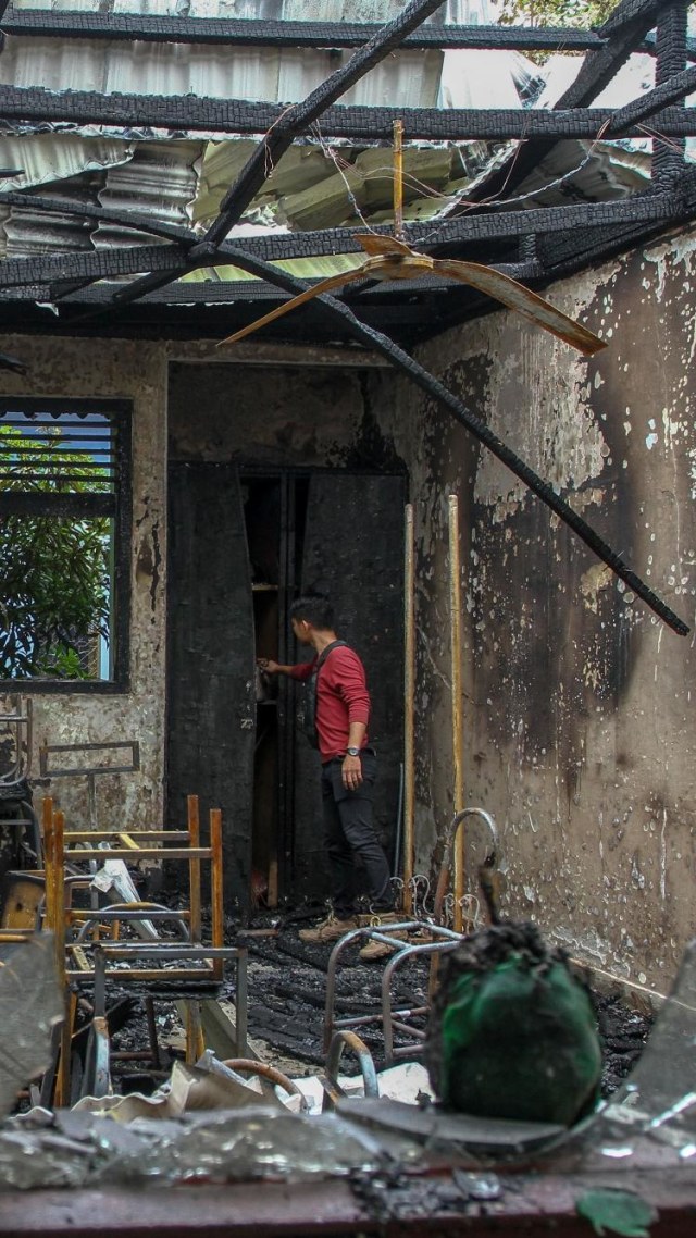 Warga melihat puing-puing sisa kebakaran yang menghanguskan bangunan SMP N 7 Pekanbaru, di Pekanbaru, Riau, Rabu (13/5/2020). Foto: ANTARA FOTO/Rony Muharrman