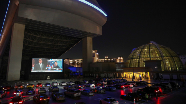 Orang-orang duduk di mobil mereka sambil menonton film di bioskop drive-in di Mall of the Emirates di Dubai, Uni Emirat Arab. Foto: REUTERS/Ahmed Jadallah