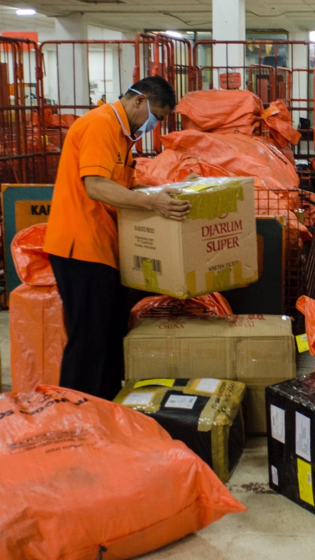 Seorang pekerja menyortir paket dan logistik yang akan didistribusikan di PT Pos Indonesia (Persero), Bandung, Jawa Barat, Kamis (14/5). Foto: Antara/Novrian Arbi