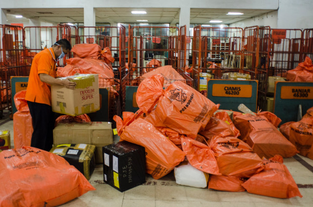 Sejumlah pekerja menyortir paket dan logistik yang akan didistribusikan di PT Pos Indonesia (Persero), Bandung, Jawa Barat, Kamis (14/5). Foto: Antara/Novrian Arbi