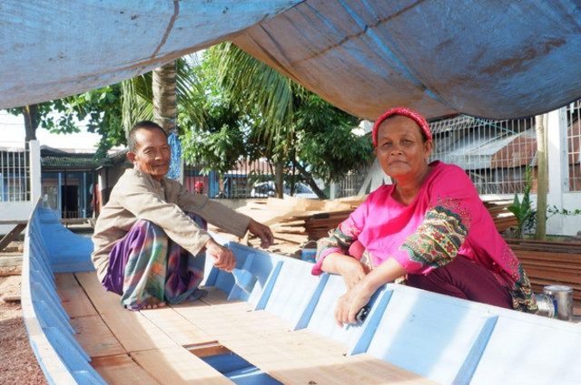 Rustam (kiri) bersama istri Nur Maidah (kanan) saat sedang membuat Perahu Gubang. | Photo by Karja/Titiantoro