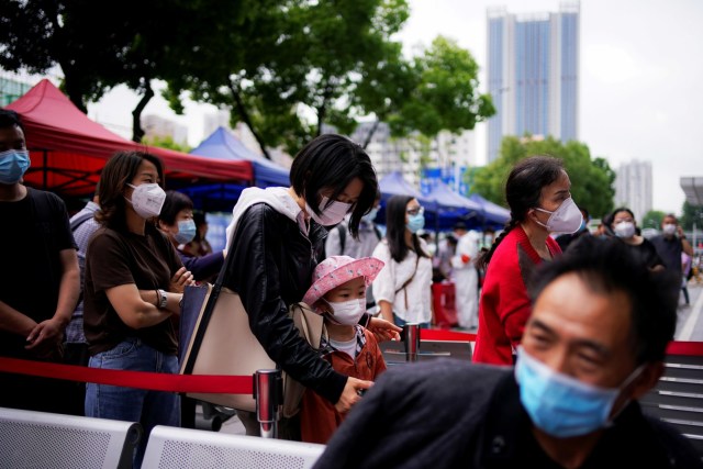 Warga mengenakan masker saat mengantre untuk melakukan tes asam nukleat di Wuhan, Hubei, China, Sabtu (16/5). Foto: REUTERS/Aly Song