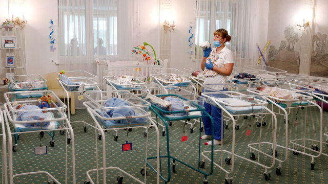 Perawat menggendong bayi yang baru lahir di Hotel Venice di Kiev, Ukraina, Jumat (15/5). Foto: AFP/SERGEI SUPINSKY