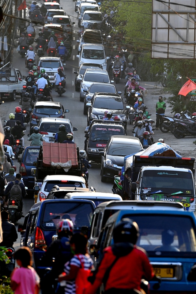 Pengendara motor dan mobil antre melintas saat terjadi keramaian lalu lintas di Jalan Raya Sawangan, Depok, Jawa Barat, Sabtu (16/5/2020). Foto: ANTARA FOTO/Sigid Kurniawan