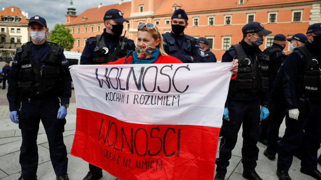 Petugas polisi berjaga saat protes anti-pemerintah di tengah penyebaran virus corona di Warsawa, Polandia. Foto: REUTERS/Kacper Pempel