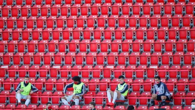 Pemain Bayern Muenchen duduk di tribun yang kosong di Stadion Alten Forsterei, Berlin, Jerman, Minggu (17/5). Foto: Reuters/Hannibal Hanschke/Pool DFL