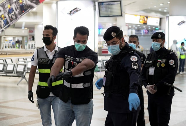 Warga Kuwait memakai masker di tengah pandemi corona. Foto: Reuters/Stephanie McGehee
