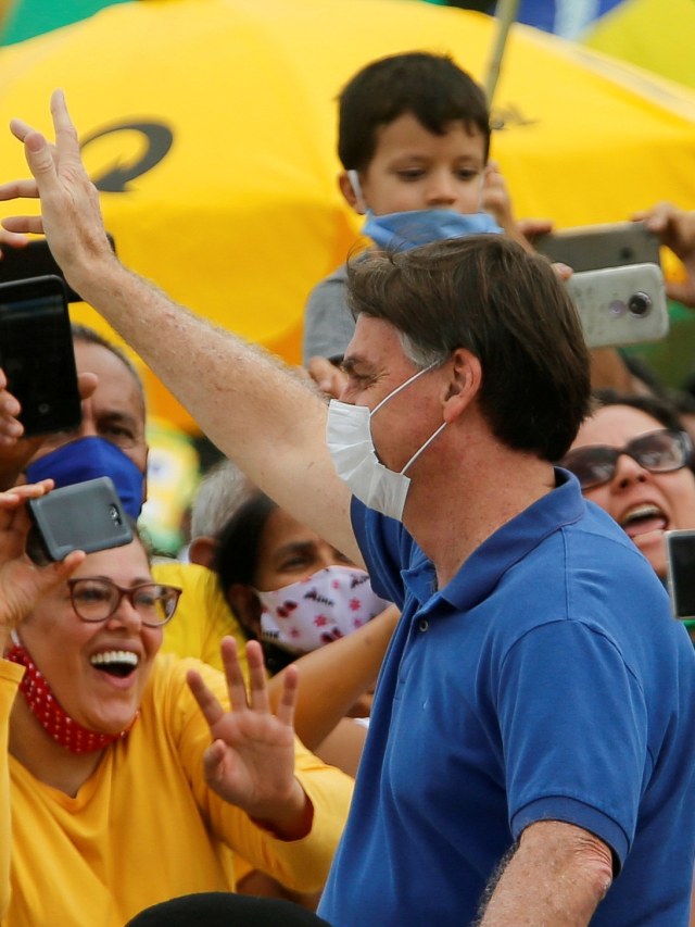 Presiden Brasil Jair Bolsonaro menyapa pendukungnya selama aksi protes di Brasilia, Brasil. Foto: REUTERS / Adriano Machado