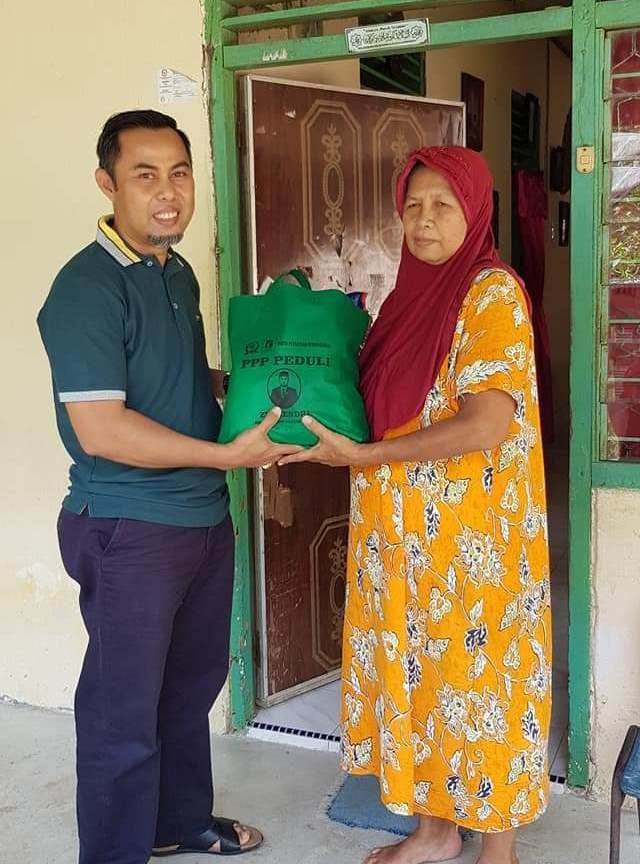 WAKIL Ketua DPRD Kuantan Singingi, Riau, Zulhendri Nazaruddin, menyerahkan paket sembako dari gaji pokok tak diambilnya selama menjabat lima tahun.  