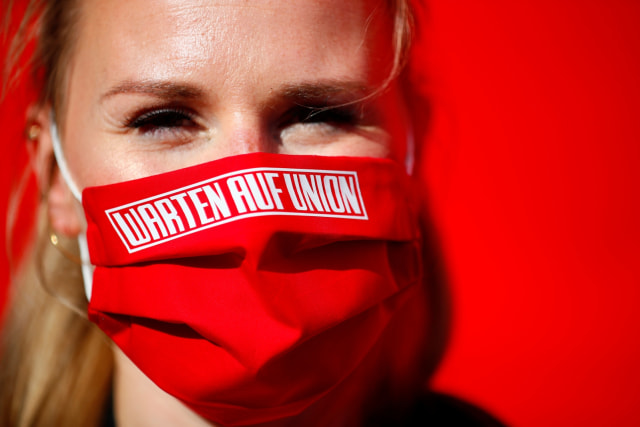 Seorang wanita mengenakan masker bertuliskan "Menunggu Union" dalam pertandingan Union Berlin vs Bayern Muenchen. Foto: AFP/Pool