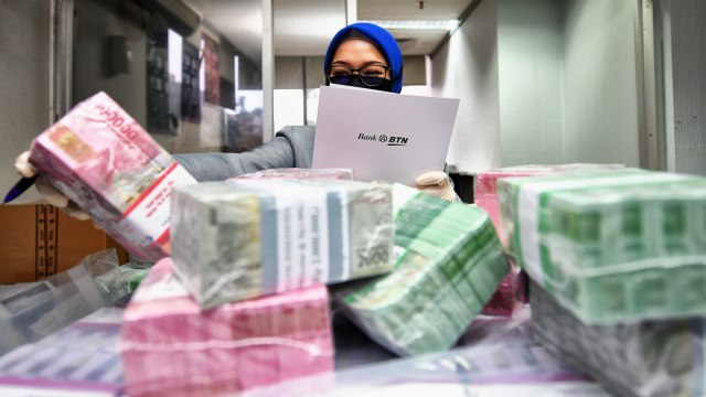 Seorang Petugas Teller PT Bank Tabungan Negara (Persero) Tbk. sedang menghitung uang kertas di Kantor Cabang Harmoni, Jakarta, Senin (18/5). Foto: Dok. BTN