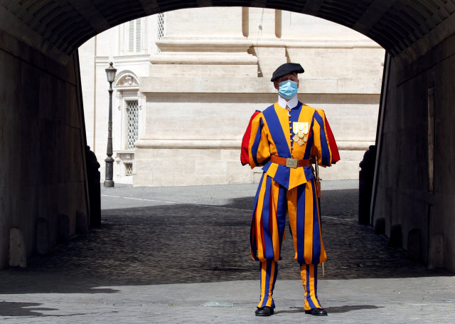 Seorang Swiss Guard terus mengawasi pada hari pertama pembukaan kembali Basilika Santo Petrus, Vatikan. Foto: REUTERS / Remo Casilli