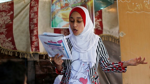 Seorang gadis Palestina Fajr Hmaid (13) mengajar anak-anak tetangganya pelajaran bahasa Arab di rumah keluarganya di Gaza, Selasa (19/5). Foto: REUTERS / Mohammed Salem