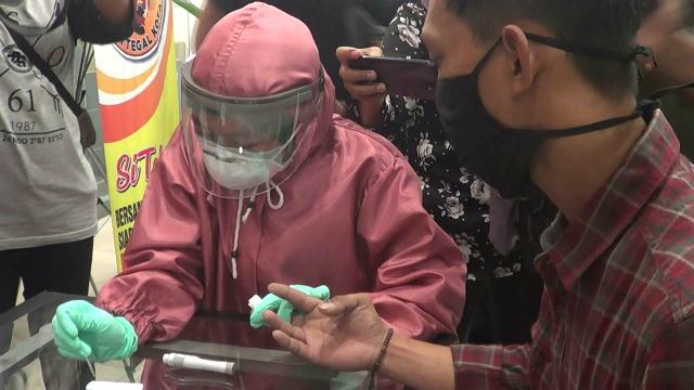 Pengunjung Pasifik Mal menjalani rapid test oleh petugas medis berpakaian lengkap, Selasa (19/5/2020) (Foto: Syaifullah)