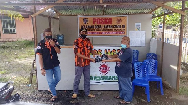 Pembagian masker oleh Pemuda Pancasila di salah satu posko COVID-19 yang ada di Kecamatan Bintauna