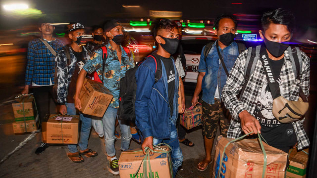 Calon pemudik terjaring razia penyekatan berjalan menaiki bus yang akan membawa mereka ke Terminal Pulogebang, Jakarta, di Pintu Tol Cikarang Barat, Bekasi. Foto: Antara/NOVA WAHYUDI