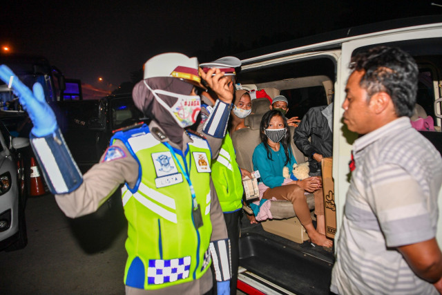 Petugas mengarahkan calon pemudik yang terjaring razia penyekatan di Pintu Tol Cikarang Barat, Bekasi, Jawa Barat, Kamis (21/5). Foto: ANTARA FOTO/Nova Wahyudi