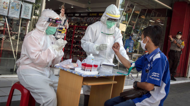 Petugas mengambil sampel darah untuk dilakukan rapid test kepada karyawan dan pengunjung Pusat Perbelanjaan di Sragen, Jawa Tengah. Foto: ANTARA FOTO/Mohammad Ayudha