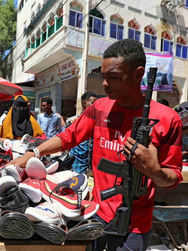 Seorang warga membawa senjata mainan di pasar di distrik Hamarweyne, Mogadishu, Somalia. Foto: REUTERS/Feisal Omar
