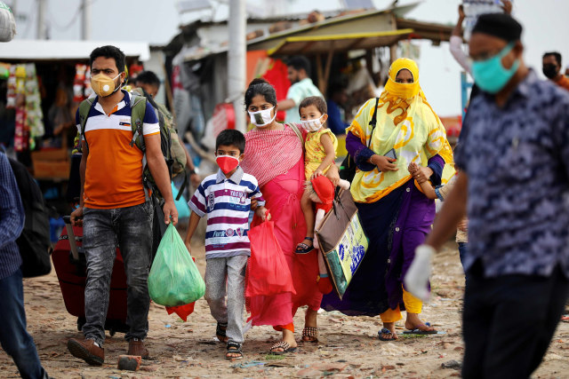 Pemudik membawa barang dan anak-anak saat akan menaiki kapal feri di Munshiganj, Bangladesh. Foto: REUTERS/Mohammad Ponir Hossain